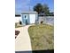 Charming blue shed with a white door and decorative landscaping in the backyard at 599 Carmel Rd, Venice, FL 34293