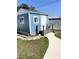 Quaint blue shed with white trim, surrounded by a landscaped yard and walkway at 599 Carmel Rd, Venice, FL 34293