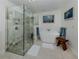 Bathroom with a glass shower, modern tub, and natural light from overhead at 601 Apalachicola Rd, Venice, FL 34285