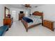 Spacious bedroom with tile floor, wood furniture, ceiling fan, and shuttered windows at 601 Apalachicola Rd, Venice, FL 34285