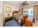 Cozy bedroom featuring a wooden bed frame, ceiling fan, and sliding glass doors to a pool at 601 Apalachicola Rd, Venice, FL 34285