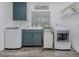 Well-lit laundry room with washer, dryer, utility sink, and ample storage space at 601 Apalachicola Rd, Venice, FL 34285
