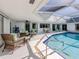Charming poolside area with comfortable wicker seating and a covered, screened-in pool at 601 Apalachicola Rd, Venice, FL 34285