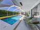 Inviting screened-in pool area with lounge chairs and outdoor seating at 601 Apalachicola Rd, Venice, FL 34285