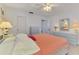 Cozy bedroom with light walls, dresser, ceiling fan, and salmon-colored bedding at 6146 Rockefeller Ave, Sarasota, FL 34231