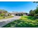 Charming home featuring an expansive green lawn and long paved driveway at 6146 Rockefeller Ave, Sarasota, FL 34231