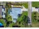 Aerial view of home with pool, screened lanai, lush lawn, and mature landscaping at 6216 Pecan Rd, Venice, FL 34293