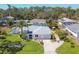 Aerial view of a charming home featuring a well-manicured lawn, inviting front entrance, and tropical landscaping at 6216 Pecan Rd, Venice, FL 34293