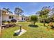 Landscaped backyard showcasing garden, bird bath, and white shed against a blue sky at 6216 Pecan Rd, Venice, FL 34293
