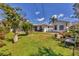 Beautiful backyard featuring lush lawn, garden, white fence, and sunny patio area at 6216 Pecan Rd, Venice, FL 34293