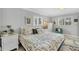 Calm bedroom with patterned bedding, neutral decor, and bright windows at 6216 Pecan Rd, Venice, FL 34293