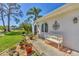 Charming front entrance with decorative accents, a welcoming bench, and colorful potted plants along the walkway at 6216 Pecan Rd, Venice, FL 34293
