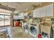 Spacious laundry room equipped with a washer, dryer, and abundant storage cabinets at 6216 Pecan Rd, Venice, FL 34293