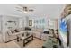 Cozy living room with a large sectional sofa, glass coffee table, and plenty of natural light at 6216 Pecan Rd, Venice, FL 34293