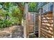 Rustic outdoor shower enclosed with wood and surrounded by mature trees and shrubbery at 6216 Pecan Rd, Venice, FL 34293