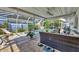 Screened in patio area with brick pavers, fan, and furniture overlooking a pool at 6216 Pecan Rd, Venice, FL 34293