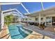 Inviting screened-in pool area with comfortable seating and lush tropical landscaping, perfect for outdoor relaxation at 6216 Pecan Rd, Venice, FL 34293