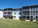 Exterior view of a two-story condo complex with screened balconies and well-maintained landscaping at 649 S Tamiami S Trl # 304, Venice, FL 34285