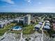 Stunning aerial view of the condo building, pool, and beach on a sunny day, with a vibrant neighborhood backdrop at 700 Golden Beach Blvd # 224, Venice, FL 34285