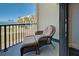 Outdoor balcony with lounge chair set overlooking tropical and beach area at 700 Golden Beach Blvd # 224, Venice, FL 34285