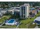 A beautifully landscaped condo building with a refreshing pool, palm trees, and plenty of lounge chairs and tables at 700 Golden Beach Blvd # 224, Venice, FL 34285