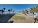 Exterior view of beachside condo with palm trees and distant views of the ocean and pool at 700 Golden Beach Blvd # 224, Venice, FL 34285