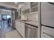 Well-equipped kitchen with stainless steel appliances, modern cabinets, sink, and adjacent laundry area at 700 Golden Beach Blvd # 224, Venice, FL 34285