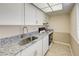 Efficient kitchen with white cabinets, granite countertops, and modern appliances at 700 Golden Beach Blvd # 224, Venice, FL 34285