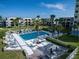 A sparkling pool surrounded by lush greenery, swaying palms, and comfortable lounge chairs and tables for residents at 700 Golden Beach Blvd # 224, Venice, FL 34285