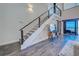 Modern staircase with wooden steps, stainless steel railing, adjacent to a living area and ocean view at 700 Golden Beach Blvd # 224, Venice, FL 34285