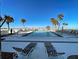 Resort-style swimming pool with beach access, palm trees, and plenty of lounge chairs at 700 Golden Beach Blvd # 224, Venice, FL 34285