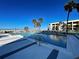 Outdoor swimming pool surrounded by palm trees and lounge chairs overlooking the ocean at 700 Golden Beach Blvd # 224, Venice, FL 34285