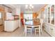 Bright dining area featuring a wooden table, white chairs, and built-in hutch at 72 Circlewood Dr # A2-7, Venice, FL 34293