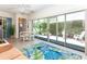 Florida room with patio view, sliding glass doors, and seating for four people at 72 Circlewood Dr # A2-7, Venice, FL 34293