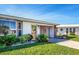 Inviting home featuring lush landscaping, decorative stone accents, and a covered carport at 72 Circlewood Dr # A2-7, Venice, FL 34293