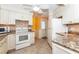 View of the kitchen featuring white appliances and light countertops at 72 Circlewood Dr # A2-7, Venice, FL 34293