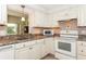 Kitchen showcasing white appliances, light countertops, and ample cabinet space at 72 Circlewood Dr # A2-7, Venice, FL 34293