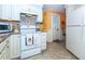 Bright kitchen featuring white cabinets, stainless steel appliances, and tile flooring at 72 Circlewood Dr # A2-7, Venice, FL 34293