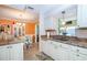 Kitchen area leading to a dining area with charming white cabinets and modern appliances at 72 Circlewood Dr # A2-7, Venice, FL 34293