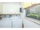 Laundry room with full-size washer and dryer, along with ample storage space at 72 Circlewood Dr # A2-7, Venice, FL 34293