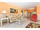 Inviting living room showcasing coral walls, ample seating, and tile flooring at 72 Circlewood Dr # A2-7, Venice, FL 34293