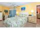 Inviting main bedroom with tropical bedding, a desk, and an ensuite entrance at 72 Circlewood Dr # A2-7, Venice, FL 34293