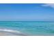 Expansive ocean view with gentle waves meeting the sandy shore under a clear blue sky at 72 Circlewood Dr # A2-7, Venice, FL 34293