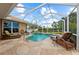 Relaxing screened pool and stone deck with lounge chairs and sunny sky at 728 Serata St, Venice, FL 34285