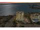 Aerial shot of building with bay views at dusk, showcasing the building's height and surrounding landscape at 770 S Palm Ave # 404, Sarasota, FL 34236