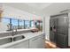 Modern kitchen features white cabinetry, stainless steel appliances, and a beautiful waterfront view at 770 S Palm Ave # 404, Sarasota, FL 34236