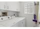 Well-lit laundry room equipped with a washer, dryer, and storage cabinets at 809 Montrose Dr # 203, Venice, FL 34293