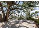 Outdoor deck shaded by mature tree offering a relaxing seating area with serene lake views at 809 Montrose Dr # 203, Venice, FL 34293