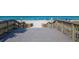 Wooden boardwalk leading to a beautiful beach with lounge chairs and clear blue waters at 8170 Casa De Meadows Dr, Englewood, FL 34224