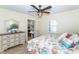 This bedroom features a dresser, ceiling fan, shuttered window, and walk-in closet at 8170 Casa De Meadows Dr, Englewood, FL 34224